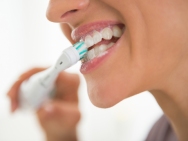 closeup on young woman brushing teeth
